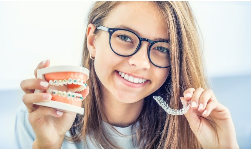 A person wearing Invisalign aligners smiles confidently, illustrating the possibility of correcting an underbite at FLOSS Dental Sugar Land in Sugar Land."
